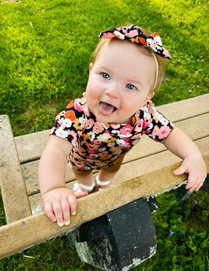 Baby girl wearing Poppies on Black Tiny Knot Headbands