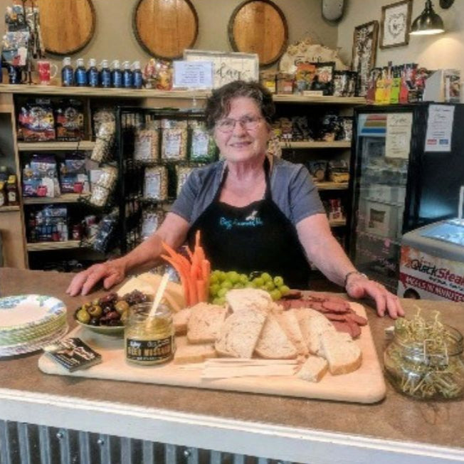 Betty, CEO Of Buzz Savories, standing next to her product